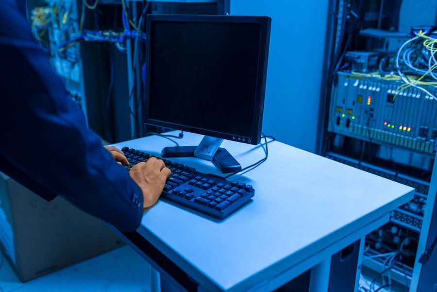 Profissional de TI administrando servidores em uma sala de servidores